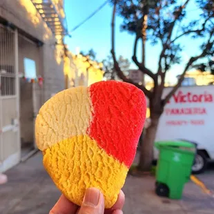 a hand holding a heart shaped cookie