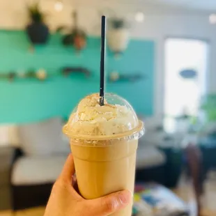 a hand holding a iced latte