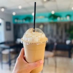 a hand holding a iced latte