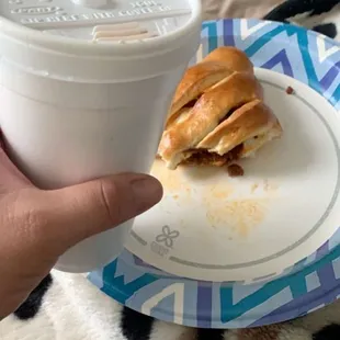 a cup of coffee and a croissant sandwich