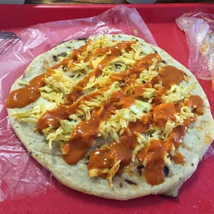 Crazy pupusa dressed with veggies and sauce