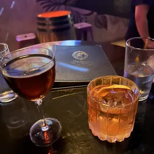 two glasses of wine and a book on a table