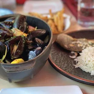 a bowl of steamed mussels and rice