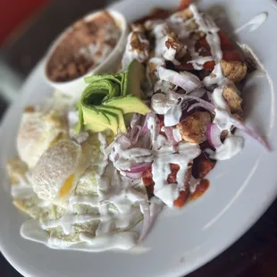 Famous chilaquiles (green with fried egg &amp; red with chicken) served with beans and ordered with avocado