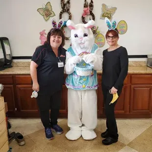 two women standing next to a white bunny