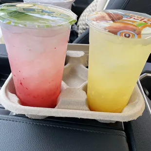 two drinks on a tray in a car