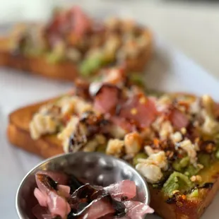 two pieces of toast with a bowl of sauce