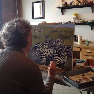 A student working on a wildlife oil painting during a private lesson at Red Door Studios.