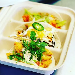 a tray of tacos and vegetables