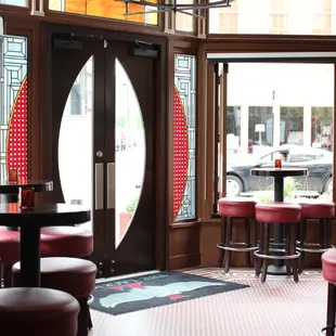 a view of a bar with red stools