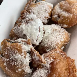 a plate of pastries with powdered sugar