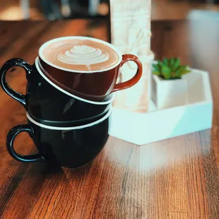 three cups of coffee on a wooden table