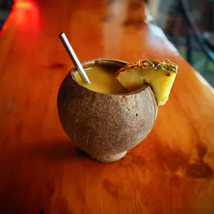 a pineapple drink in a coconut bowl