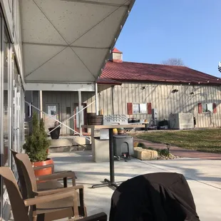 a patio with chairs and a grill