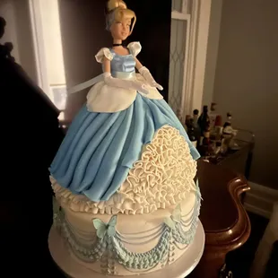 a doll on top of a cake