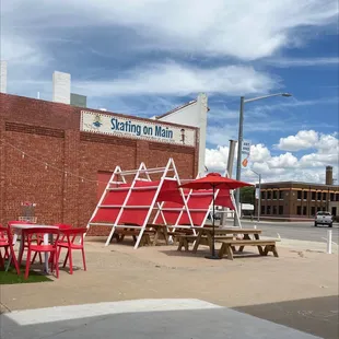 tables and umbrellas in front of a brick building