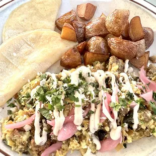 a plate of food with eggs, potatoes, and other items