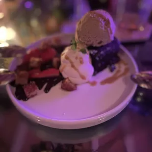 a dessert on a plate with ice cream and strawberries