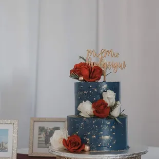 a three tiered cake with red and white roses
