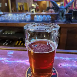 a pint of beer on a bar