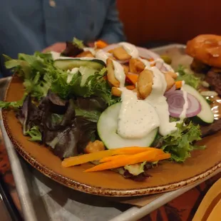 a plate of salad and a burger