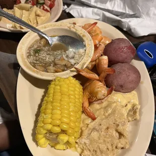 a plate of shrimp, corn, potatoes, and corn on the cob