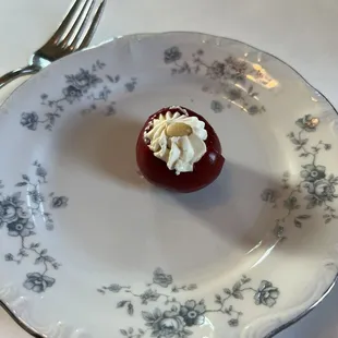 Pickled cherry pepper with cream cheese and a pine nut.