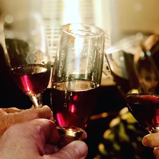 two hands holding wine glasses