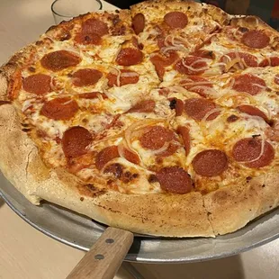 a pepperoni pizza on a pizza pan