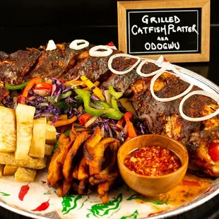 Savor our grilled catfish platter: huge catfish marinated and grilled perfectly. With fried yam, plantain, veggies &amp; signature spicy sauce