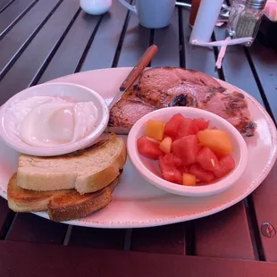 Poached eggs , ham steak, sourdough , and fresh fruit