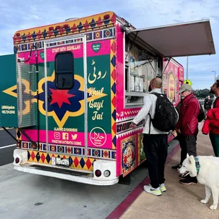  man and a dog standing in front of a food truck