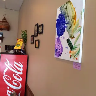 a coca cola sign and a painting on the wall