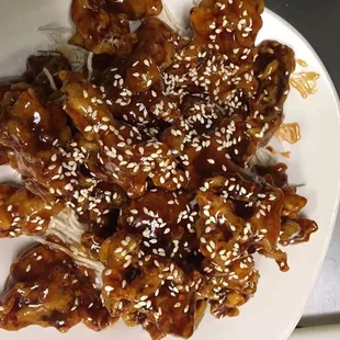 a plate of chicken with sesame seeds