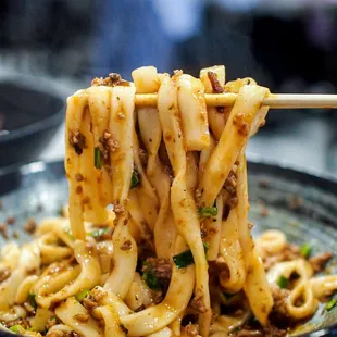 noodles being lifted by chopsticks