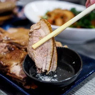 chopsticks picking up a piece of meat
