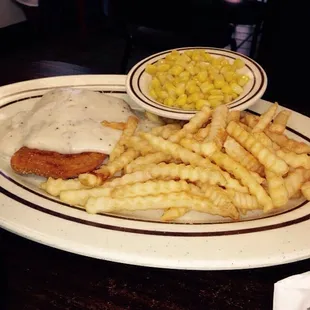 Chicken fried chicken with fries and corn.