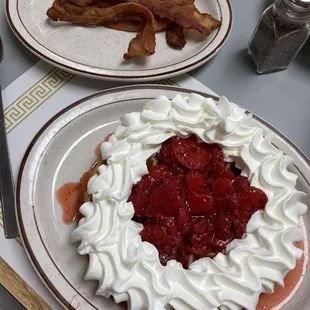 a strawberry pie with whipped cream and bacon
