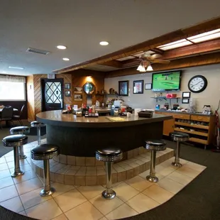 a bar with stools and a television