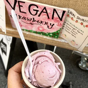 a hand holding a bowl of ice cream