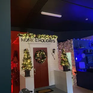 a man sitting in front of a home for the holidays display