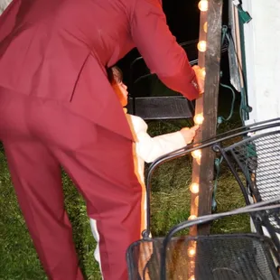 a man in a red suit bending over a chair