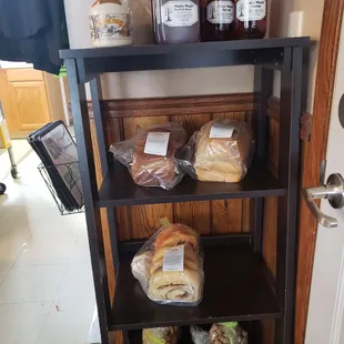 a shelf of bread, jellys, and honey