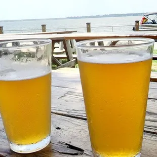 two glasses of beer on a picnic table