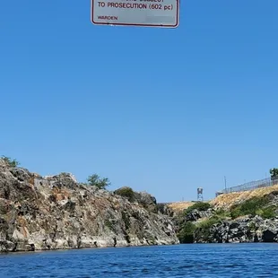Lake Natoma boundary with Folsom State Prison. Sign says, Folsom SP No trespassing Violators subject to prosecution (PC 602) 7-4-23