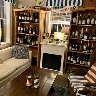 a living room with wine bottles on the shelves