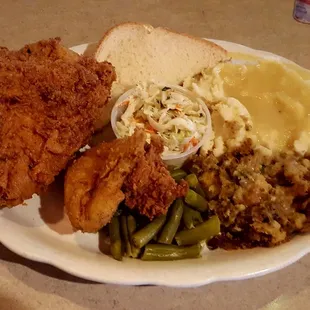 a plate of fried chicken, mashed potatoes, green beans, and mashed potatoes