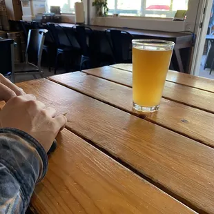 a person sitting at a table with a glass of beer