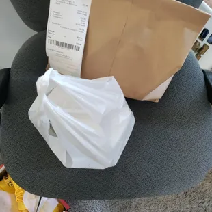 a paper bag and a receipt on a chair