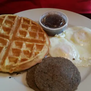 Two eggs over easy with sausage and Belgian waffle